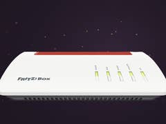 FritzBox 7590 AX-Router mit LED-Anzeigen vor dunklem Hintergrund.