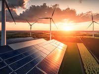 Solarpanels und Windräder im Sonnenuntergang