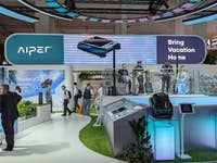 AIPER-Messe-Stand mit dem Slogan 'Bring Vacation Home' und einer Band, die auftritt.