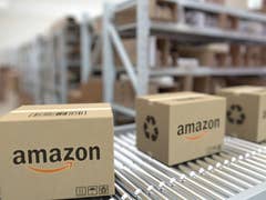 Amazon-Pakete auf einem Förderband in einem Lager.
