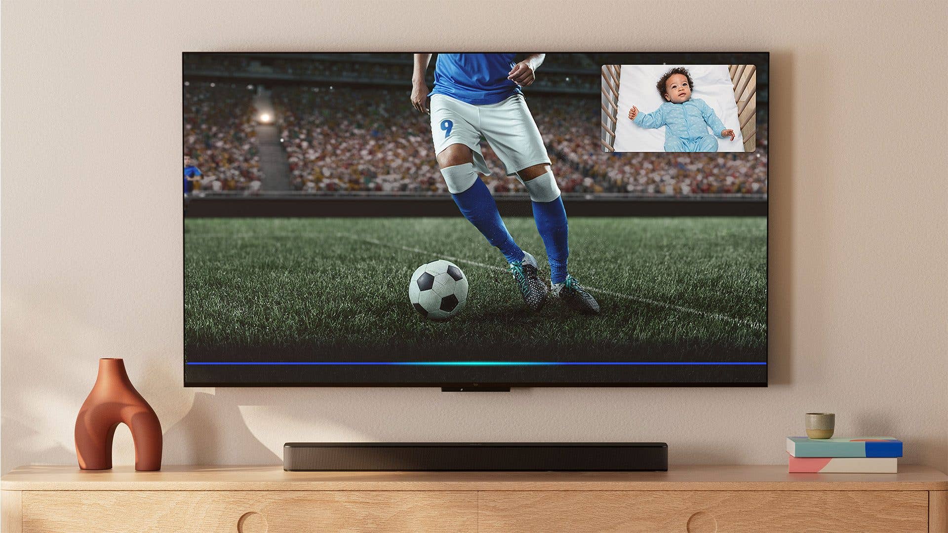 Ein Smart-TV zeigt einen Fußballspieler mit einem Babybild in der Ecke.