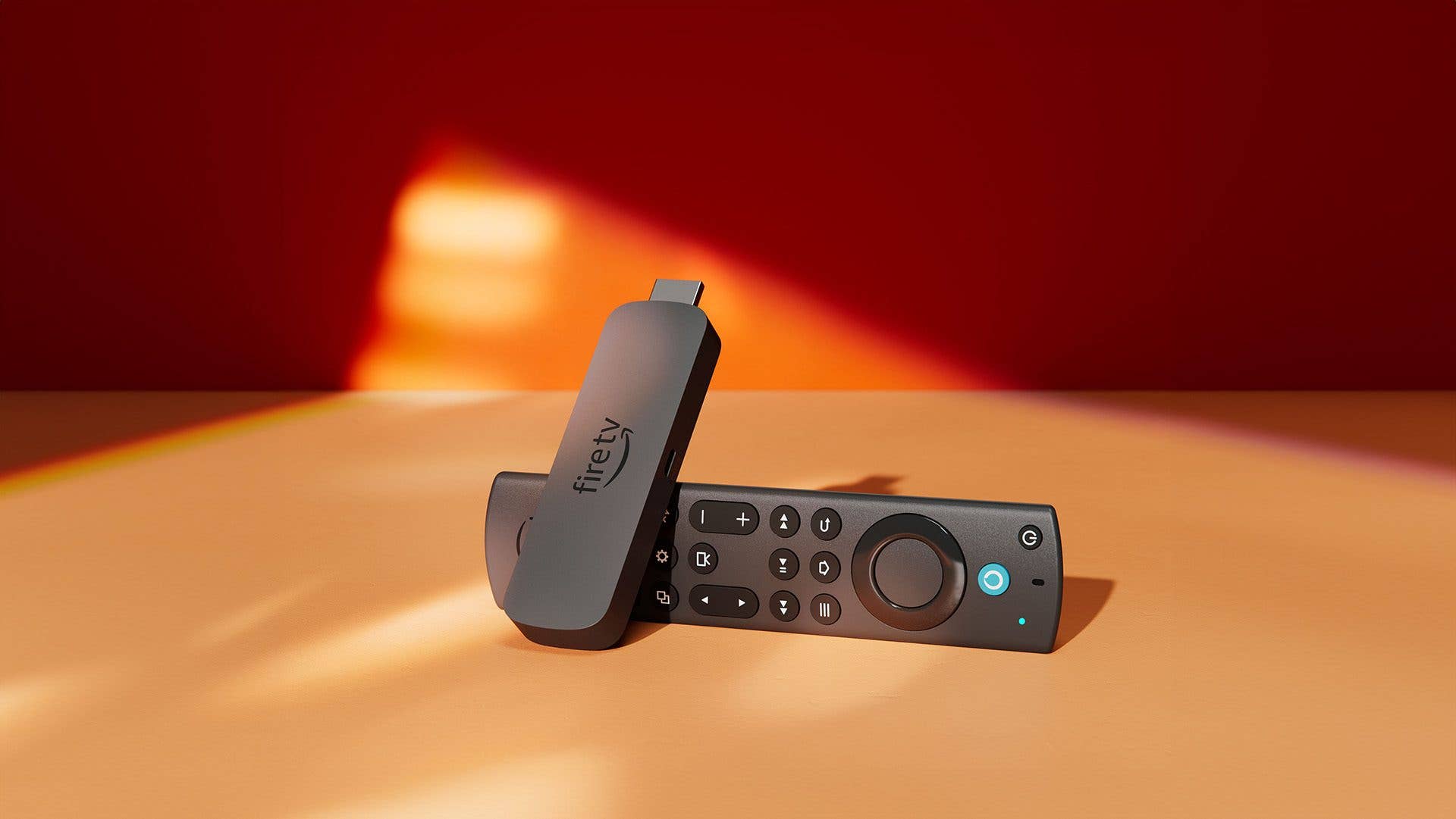 Amazon Fire TV Stick 4K Max und Fernbedienung auf einem bunten Hintergrund.