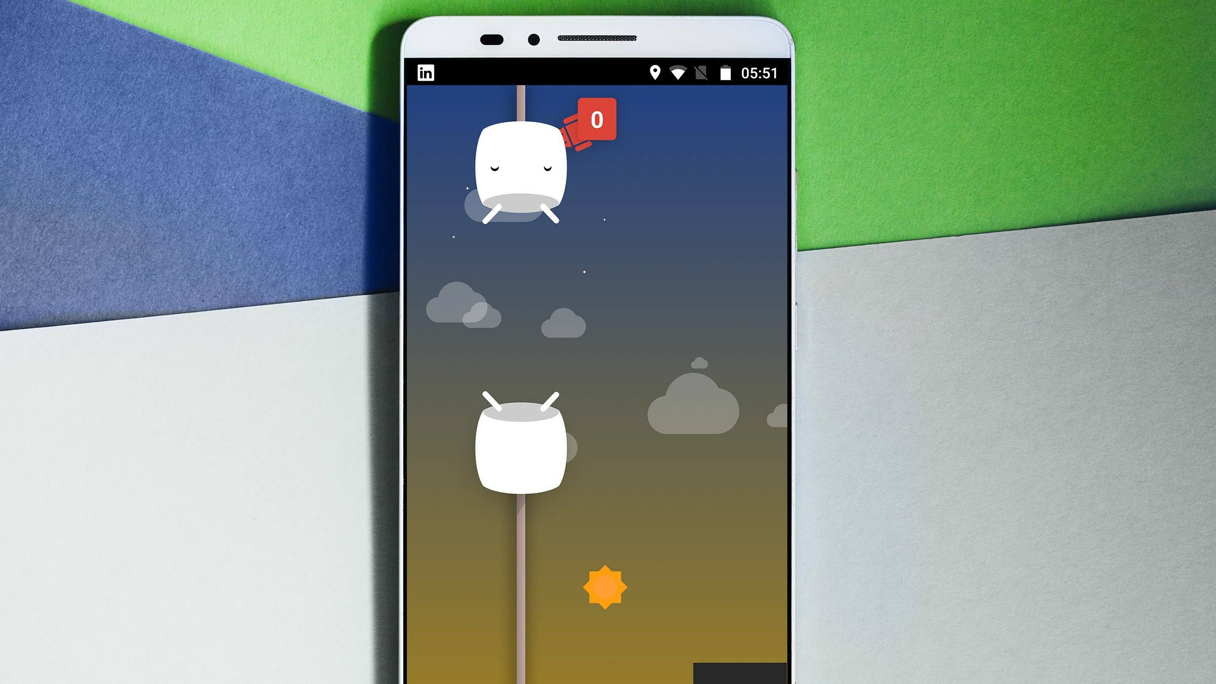 Ein Smartphone zeigt ein Spiel mit Marshmallow-Charakteren und einem Sonnen-Icon vor einem bunten Hintergrund. Ein Smartphone zeigt ein Spiel mit Marshmallow-Charakteren und einem Sonnen-Icon vor einem bunten Hintergrund.