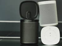 Zwei Sonos-Lautsprecher, einer schwarz und einer weiß, übereinander gestapelt mit einem Steuerpad darunter.