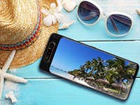 Smartphone mit Palmen-Foto auf dem Tisch