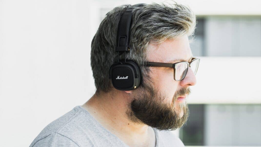 Ein Mann mit Brille trägt Marshall Major 3 Kopfhörer im Freien. Ein Mann mit Brille trägt Marshall Major 3 Kopfhörer im Freien.