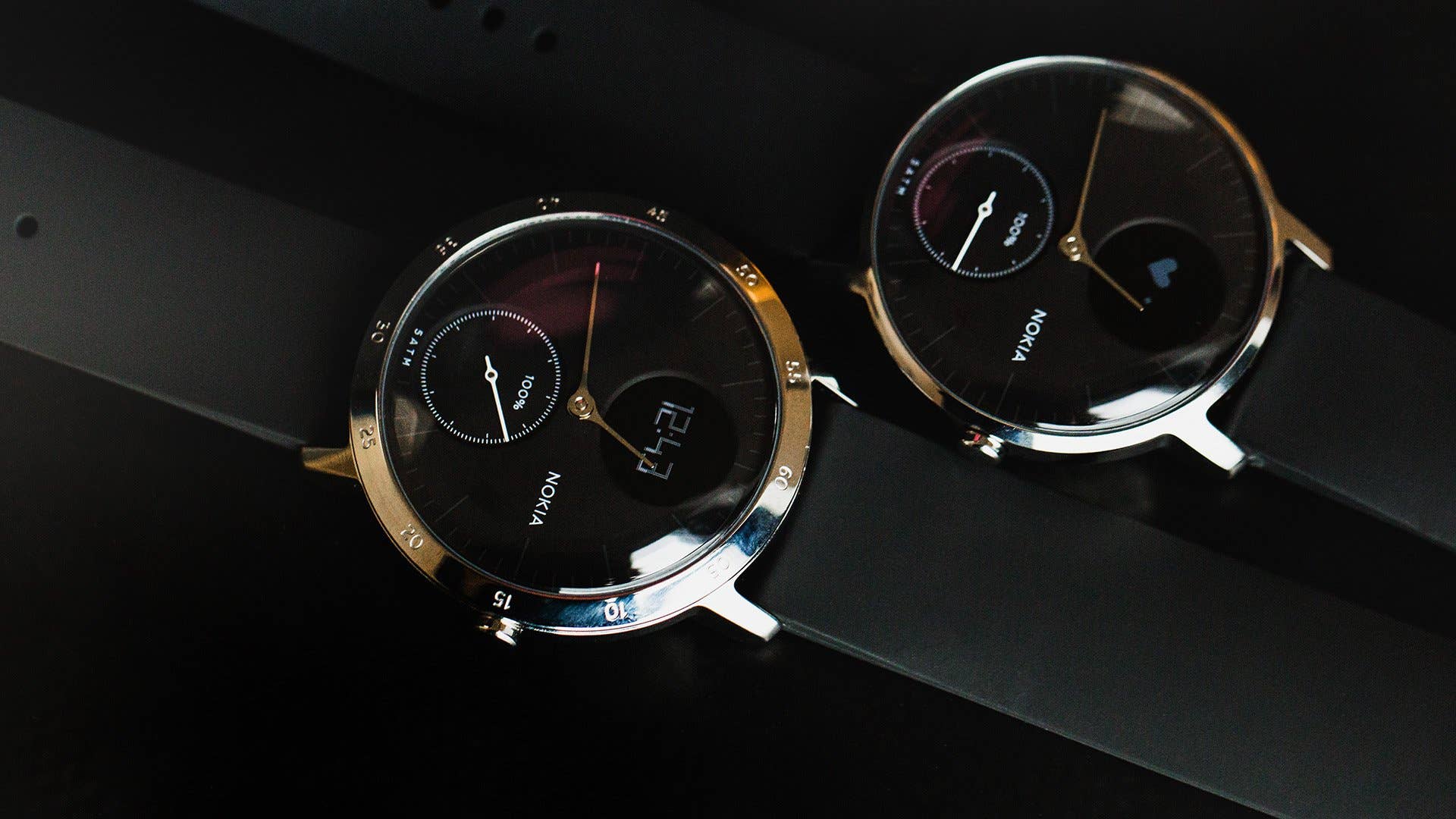 Zwei Nokia Steel HR-Uhren mit schwarzen Armbändern und analog-digitalen Anzeigen. Zwei Nokia Steel HR-Uhren mit schwarzen Armbändern und analog-digitalen Anzeigen.
