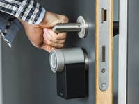 Ein Bild, auf dem jemand mit dem Nuki Smart Lock eine Tür zuschließt.
