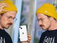 Zwei Bens, die auf das iPhone 14 schauen.
