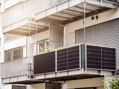 Ein Balkon mit Solarpanels an einem modernen Wohngebäude.