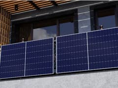 Solarmodule, die an einem Balkon eines modernen Gebäudes angebracht sind.