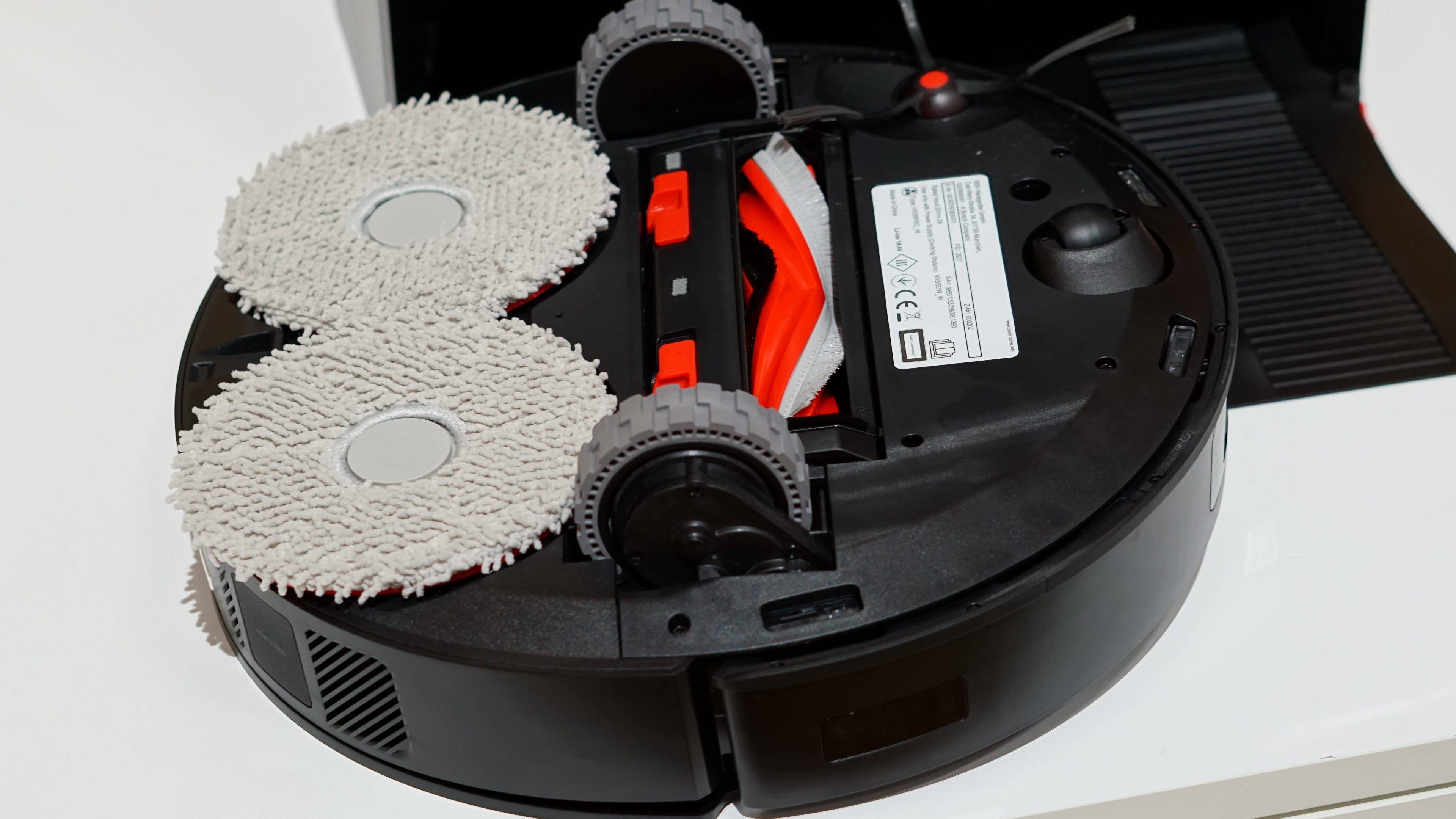 Roboter-Staubsauger mit zwei Reinigungs-Pads und sichtbarem Bedienfeld.