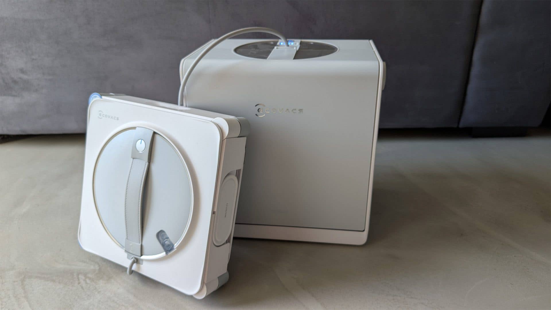 Ecovacs Fensterputzroboter Modell Winbot W2S Omni neben seiner Ladestation.