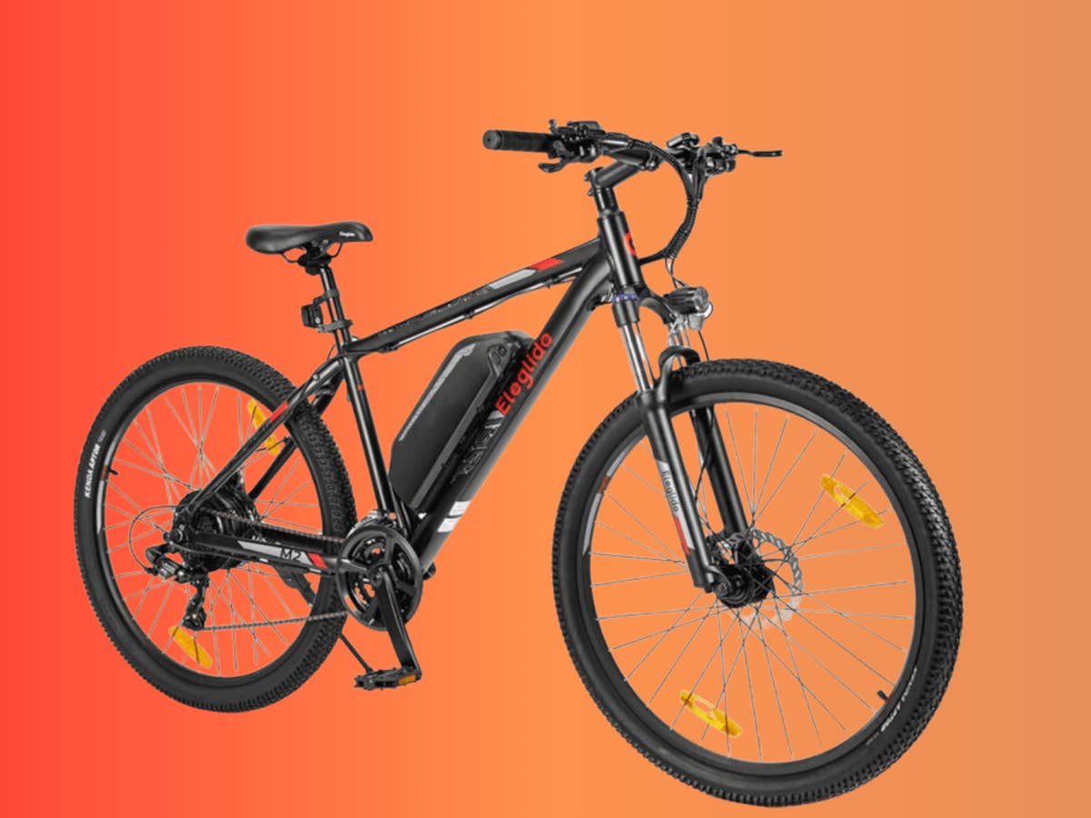 Eleglide M2 E-Bike - Vielseitiges Elektrisches Mountainbike Schwarzes Eleglide M2 E-Bike mit Akku, vor einem orangefarbenen Verlaufshintergrund.