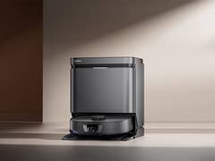 Ein Eureka J15 Max Ultra Saugroboter auf einer flachen Oberfläche in einem modernen Raum.