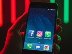 Eine Hand hält ein Smartphone, das Facebook, Instagram, WhatsApp und andere Apps auf dem Bildschirm zeigt.