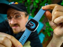 Ben, der die Fitbit Versa 4 in der Hand hält.
