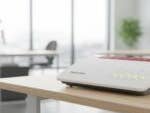 Fritz!Box 7590 AX WLAN-Router auf einem Holztisch in einer modernen Büroumgebung.