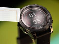 Nahaufnahme einer Garmin Fenix 7 Pro Solar Smartwatch, die Uhrzeit und Fitnessdaten anzeigt.