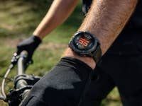 Nahaufnahme einer Garmin-Smartwatch, die Fitnessdaten am Handgelenk eines Radfahrers anzeigt.