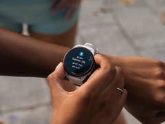 Eine Person überprüft eine Garmin Forerunner 165 Music Smartwatch, die Trainingsdetails anzeigt.