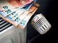 Heizkörper mit Euroscheinen darauf, Sinnbild für hohe Gaspreise