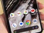 Eine Hand hält ein Smartphone, das Google Chrome und verschiedene App-Icons zeigt.