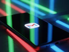 Ein Smartphone mit dem Gmail-Logo, umgeben von bunten Neonlichtern.