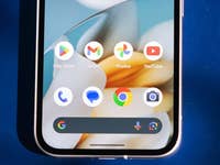 Nahaufnahme des Smartphone-Startbildschirms mit Google-Apps und Symbolen.