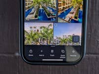 Ein Smartphone-Bildschirm zeigt eine Google Fotos-Oberfläche mit vier Bildern eines Poolbereichs und Palmen.