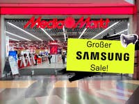 Eingang des MediaMarkt mit einem Schild, das einen großen Samsung-Verkauf ankündigt.