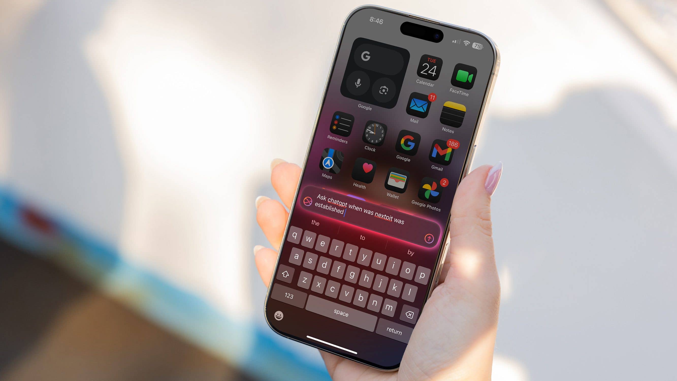 Eine Hand hält ein iPhone, das iOS 18 mit verschiedenen App-Symbolen und einer aktiven Suchleiste zeigt.