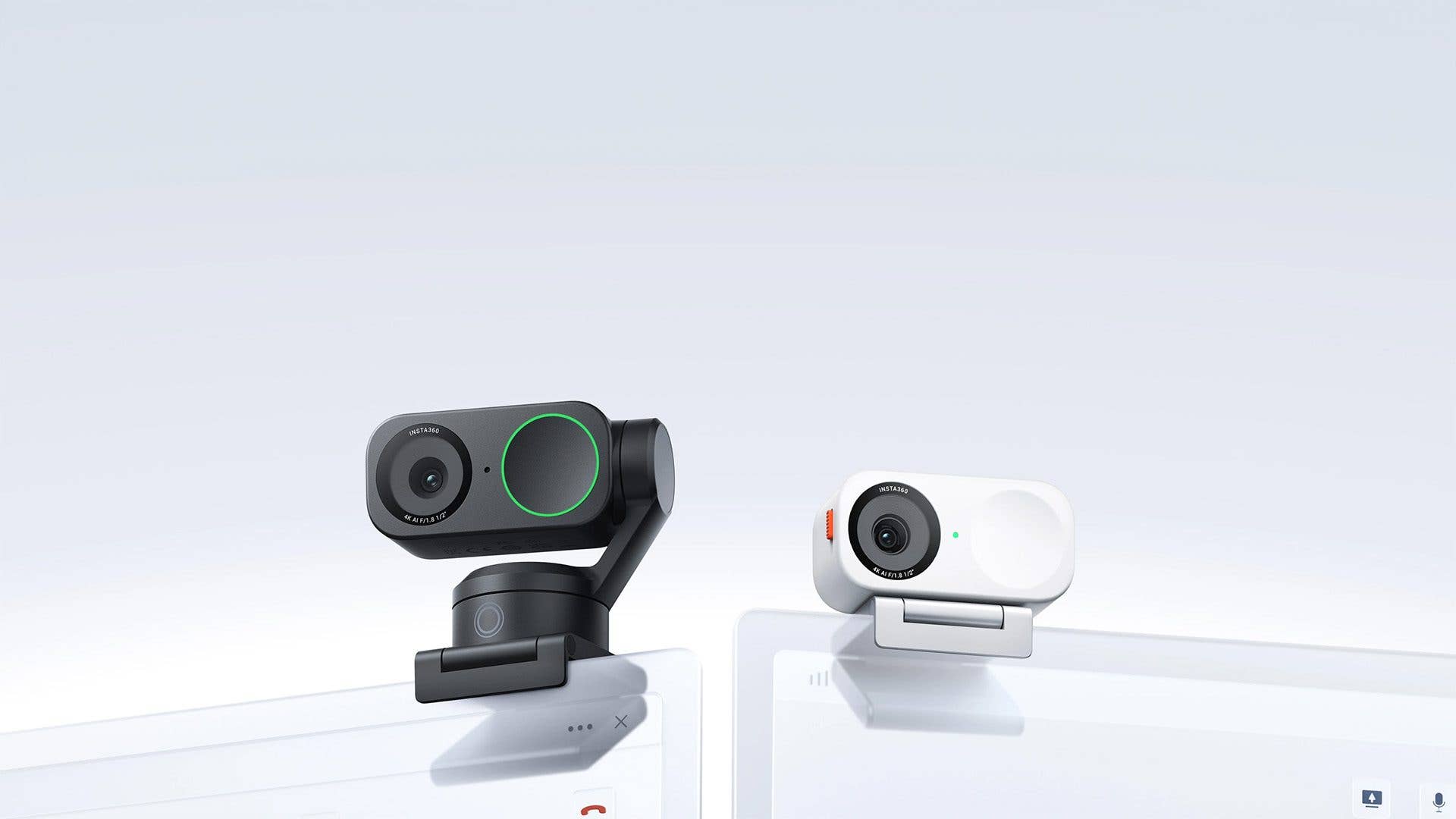 Zwei Insta360 Link 2-Webcams, eine schwarze und eine weiße, auf hellem Hintergrund.