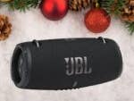Ein JBL Xtreme 3 tragbarer Lautsprecher umgeben von festlichen Weihnachtsdekorationen.