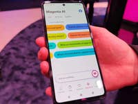 Eine Person hält ein Telekom KI-Phone, das die Benutzeroberfläche der Magenta AI-App zeigt.