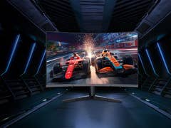 Gaming-Monitor mit gekrümmtem Bildschirm, der Rennwagen auf einer Strecke mit dynamischer Beleuchtung zeigt.