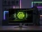 MSI MAG 275QF Gaming-Monitor, der ein neon-grünes Logo auf einem Tisch mit Gaming-Hintergrundbeleuchtung anzeigt.