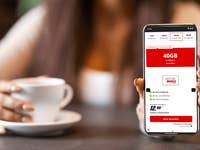 Eine Person hält ein Smartphone, das einen Mobilfunktarif mit 40GB für 12,99 € monatlich anzeigt.