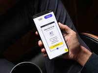 Eine Person hält ein Smartphone, das ein Mobilfunktarifangebot mit 50 GB Daten für 9,99 € anzeigt.