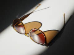 Sonnenbrille auf einer weißen Oberfläche, betont durch sanfte Schatten.