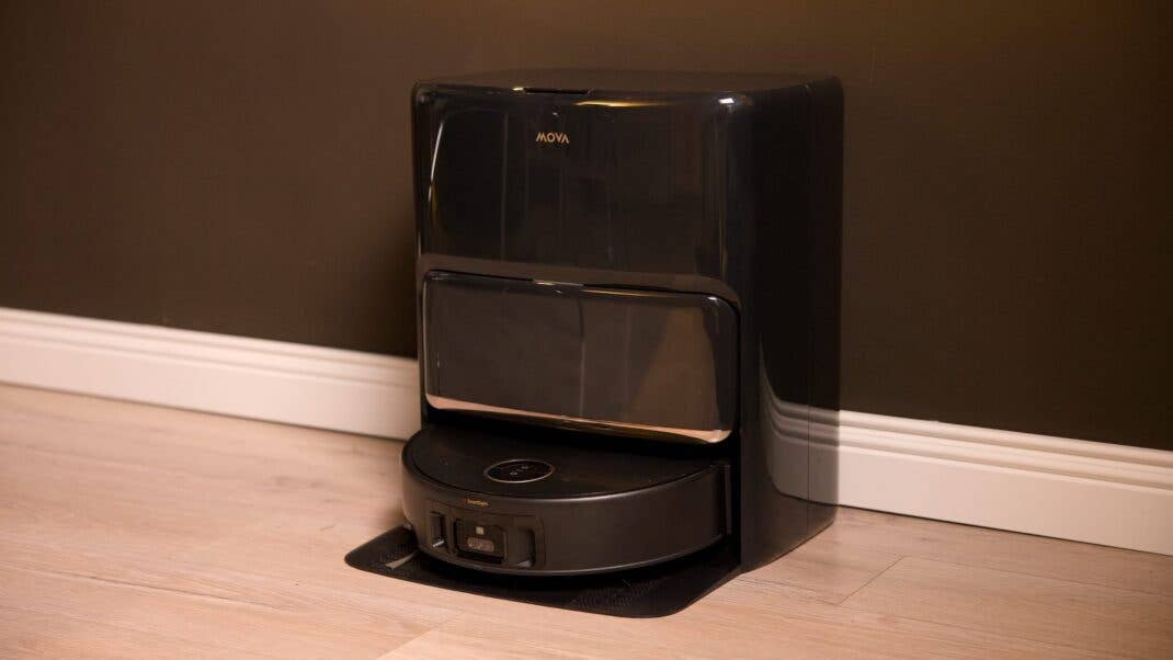 Mova Z60 Ultra Roller Complete, ein schwarzer Roboter-Reiniger vor einer dunklen Wand.