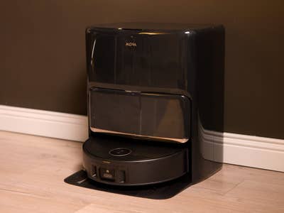 Mova Z60 Ultra Roller Complete, ein schwarzer Roboter-Reiniger vor einer dunklen Wand.