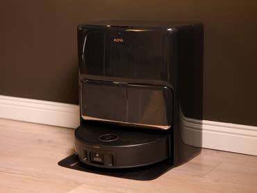 Mova Z60 Ultra Roller Complete, ein schwarzer Roboter-Reiniger vor einer dunklen Wand.