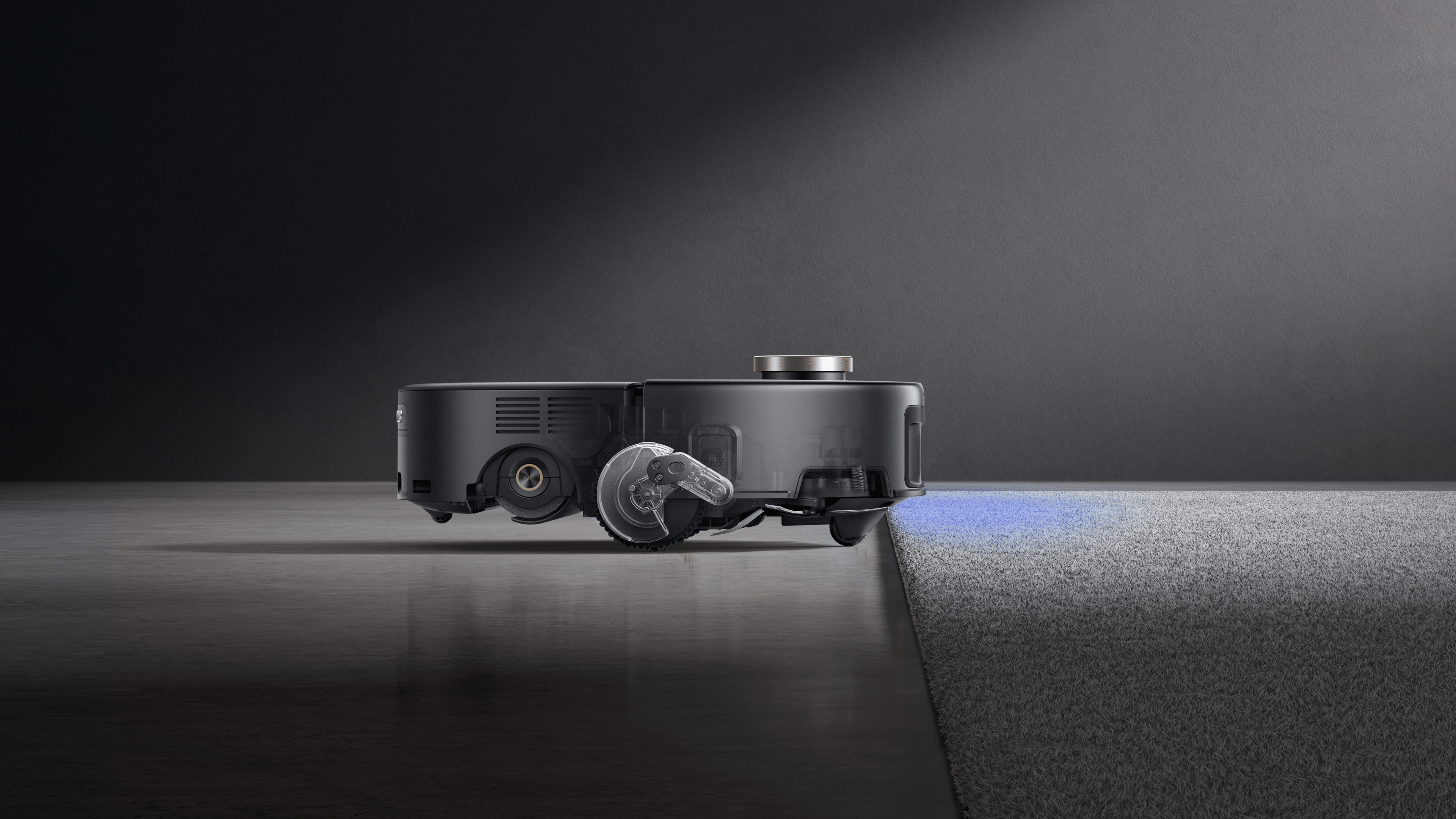 Ein Mova Z60 Ultra Roller Complete Roboterstaubsauger auf einem Boden, der von glatt zu Teppich wechselt.