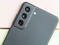 Nahaufnahme eines Samsung Galaxy S21 FE Smartphones auf pastellfarbenen Boxen.