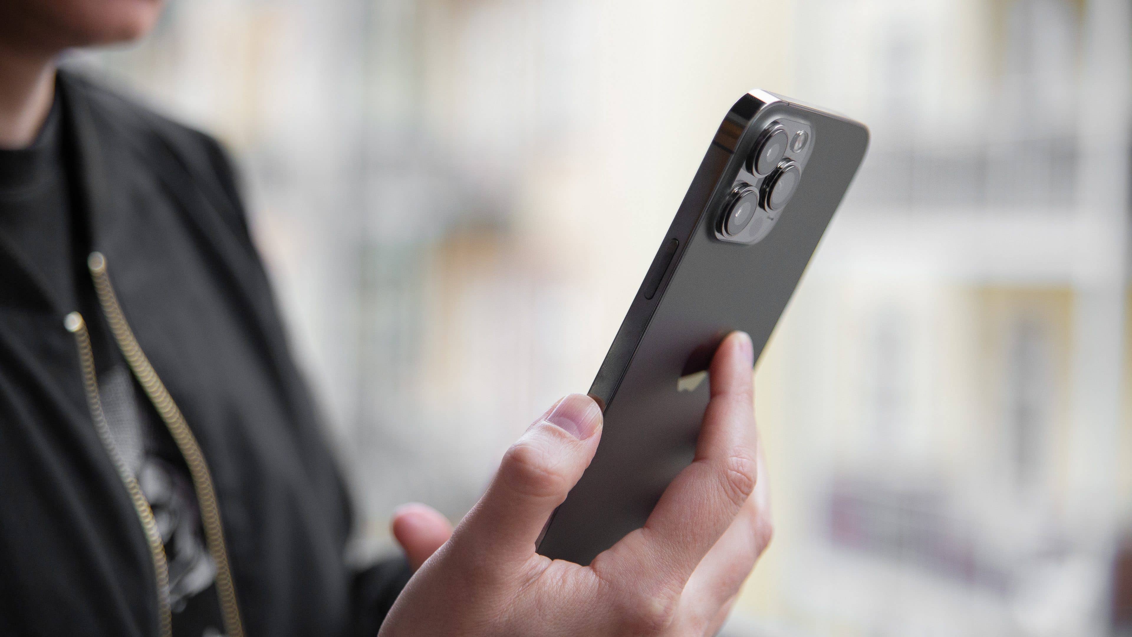 Camila, die das iPhone 13 Pro in der Hand hält.