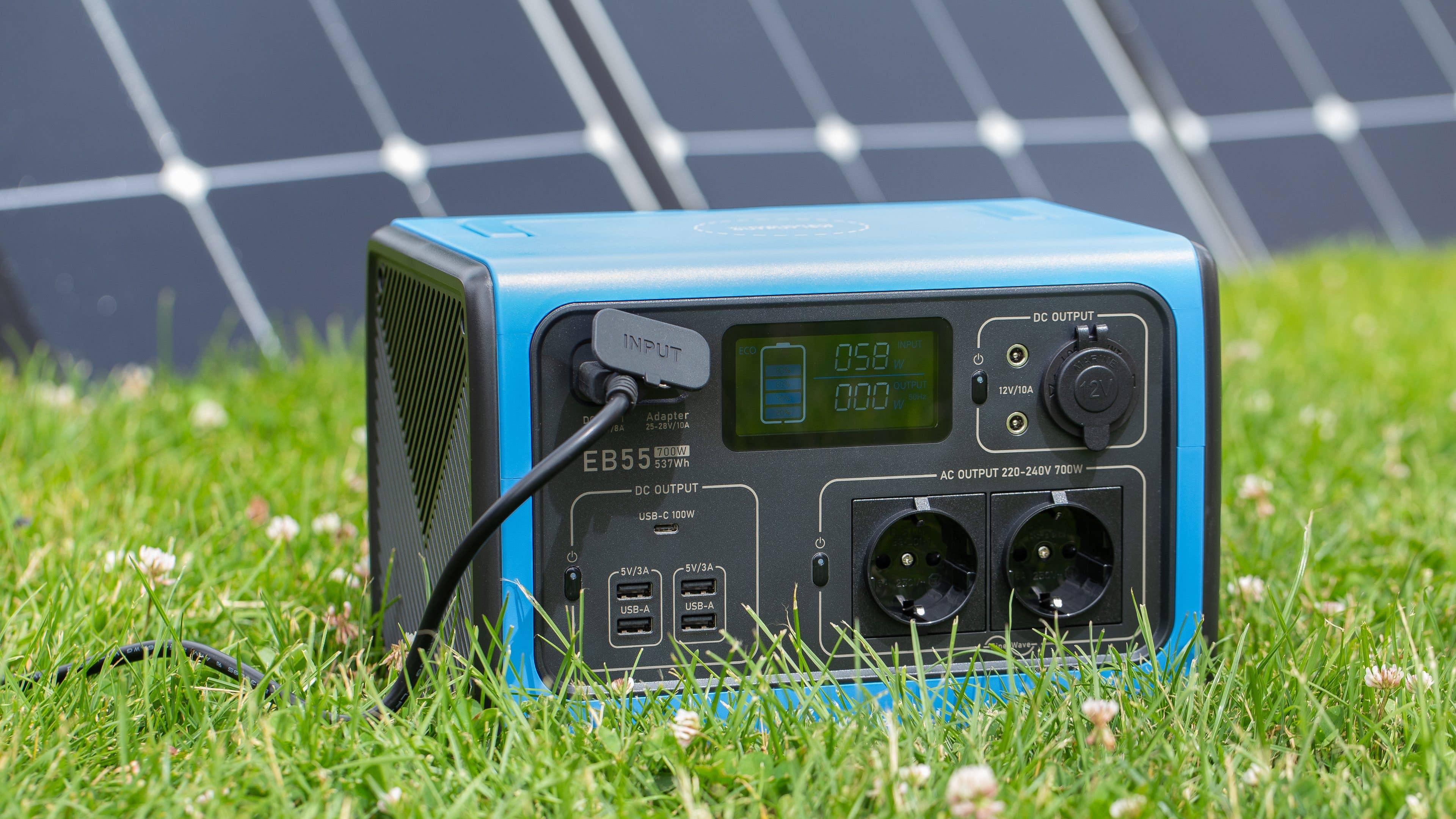 Bluetti EB55 mit Solarpanel im Hintergrund