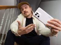 Ben sitzt auf einer Treppe und hält das Oppo Find X5 Pro in der Hand