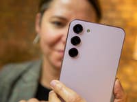 Camila schaut aufs Galaxy S23, wir sehen die Rückseite des Geräts