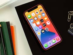 iPhone 12 mini liegt auf einem Schreibtisch mit eingeschaltetem Display